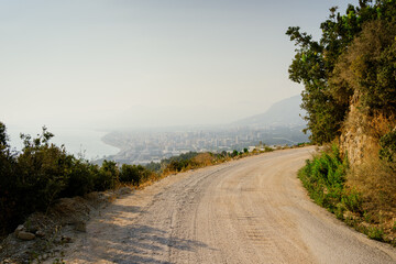 Landscape opening view on a mountain path, sea coast, city and sky. Motivation