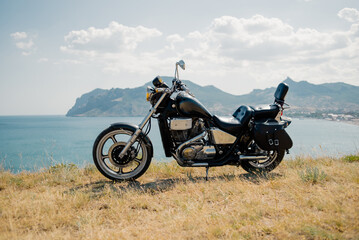 Fototapeta na wymiar Parking Motorbike on cliff near sea with mountains background