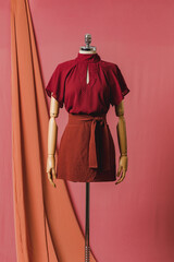 mannequin in a dress on a mannequin red pink background fashion still photography blouse skirt