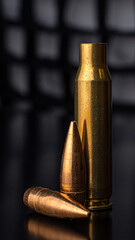 Obraz na płótnie Canvas Macro photo of a bullet and cartridge case on a black background, vertical photo, soft focus