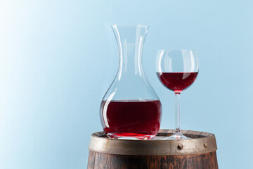 Decanter with red wine on old wooden barrel