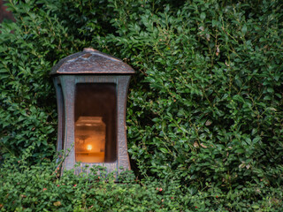 flashlight with a candle on a background of green bush