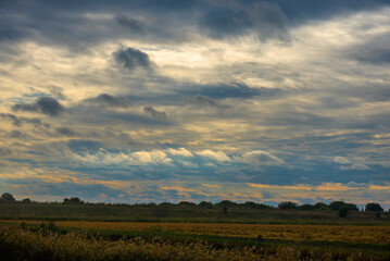 Fototapeta premium sunrise and clouds over the field in autumn
