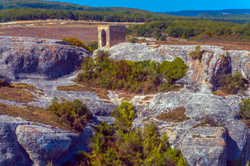 Ancient stone caves in a town-fortess Eski-Kermen high in a rocky mountains, Crimea.