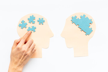 Communication. Chaos and peace in brain - two paper human heads with puzzles