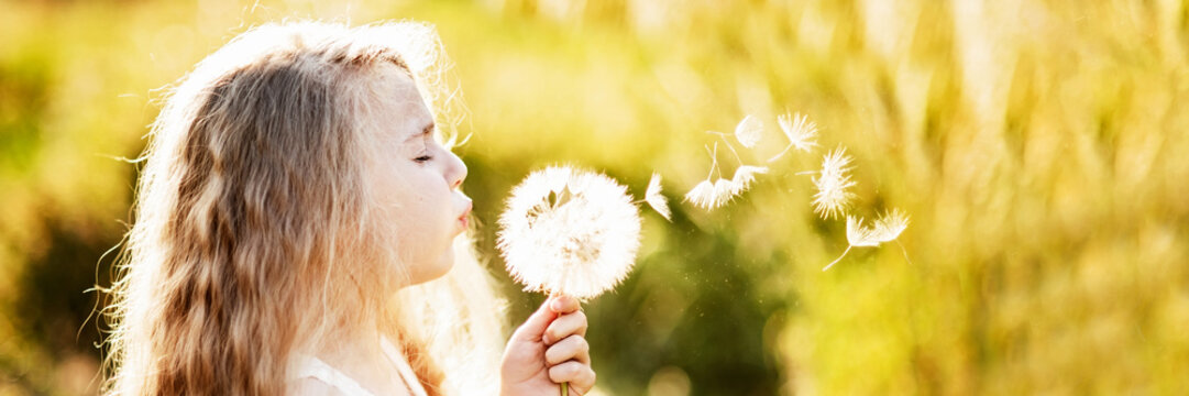 Summer portrait of girl with big dandelion. Close up photo of flower. Allergy free concept. Freedom