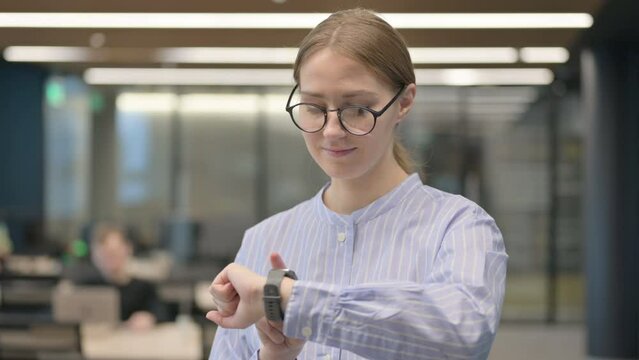 Portrait of Young Woman using Smart Watch