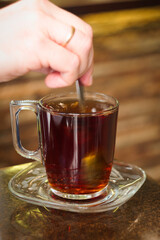 Pouring hot black Arabian tea into cup