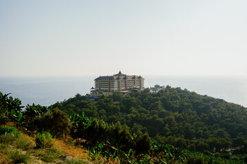 Houses on the mountain among many trees and banana plantation with beautiful sky in background