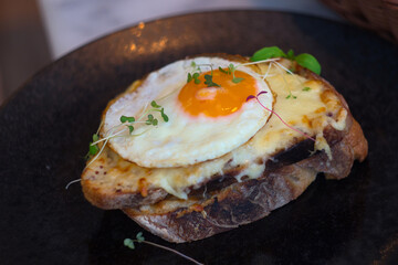 The croque madame is similar to the croque monsieur in almost every way. Both include ham, béchamel, and Gruyère cheese, but the croque madame is topped off with a fried egg 