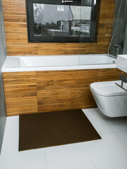 A rubber mat on the floor next to the bathtub in the bathroom. Interior design, modern bath - 488566179