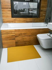 A rubber mat on the floor next to the bathtub in the bathroom. Interior design, modern bath - 488566181