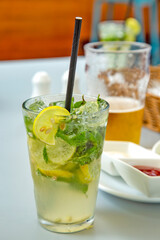 glass of mojito drink with mint and sliced lemon. 