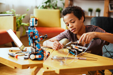 A schoolboy having making a robot and having fun at home.
