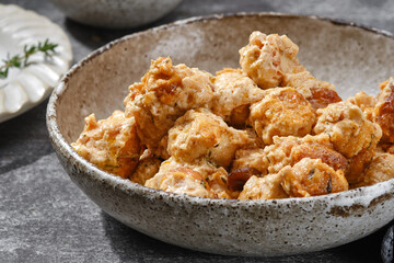 Fried meatballs with spices and cream sauce in a bowl.  Shallow depth of field