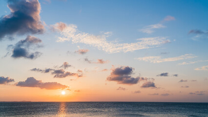 Fototapeta na wymiar Sunset sky over sea in the evening with orange sunlight clouds