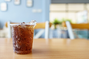 sparking water soda or cola in the plastic glass on the table