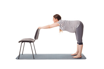 Pregnancy yoga exercise - pregnant woman doing yoga asana Uttanasana Standing Forward Fold Pose...