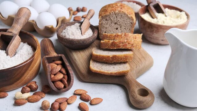 Keto bread cooking. Different types of nut flour - almond, hazelnut, cashew and baking ingredients, gray background.