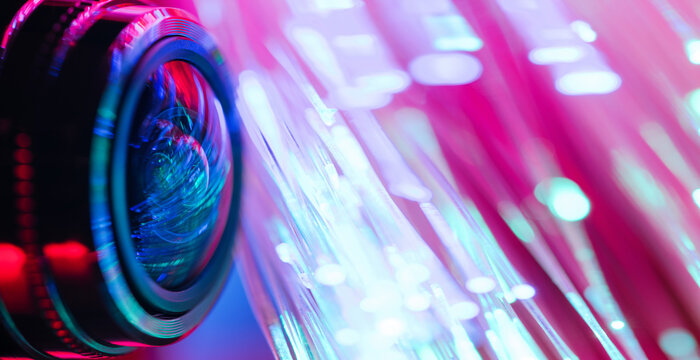 Camera lens with with multi-colored backlight. Optics. Cyberpunk style. Banner