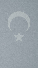 Turkey flag outline on cardboard surface. Paper texture with cellulose fibers. Mobile phone wallpaper. Light silver paperboard. Gray tinted vertical background