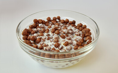 Granola filled with yogurt in a transparent bowl on a white background. Healthy food.