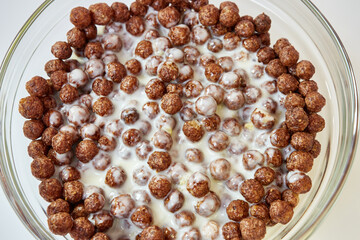 Granola filled with yogurt in a transparent bowl on a white background. Healthy food.