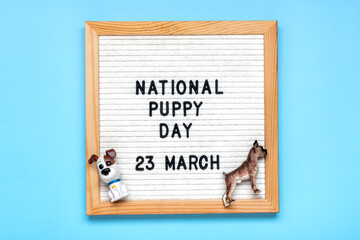 Felt board with text National puppy day in 23 march, cute dog figures on blue background Top view Flat lay Holiday greeting card