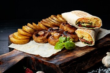 Traditional shawarma, fried potatoes and mushrooms. Turkish street food. Eastern fast food. Doner kebab with garnish