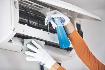Woman cleaning aircon filters indoor unit at home.