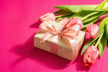 Greeting concept flower composition, a bouquet of pink tulips, and a gift.