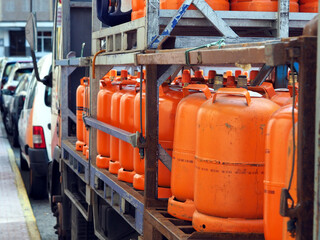 LPG cylinders. Orange bottles with butane.Truck delivered propane cylinders. Many gas tanks - obrazy, fototapety, plakaty