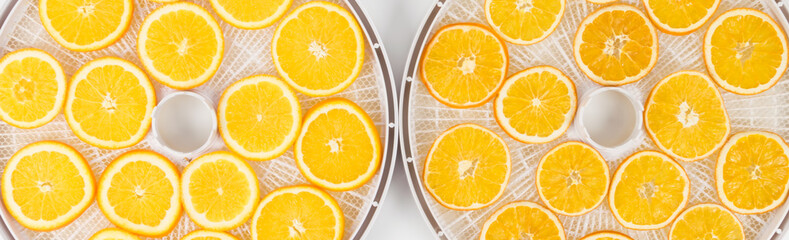 dried orange slices lie on drying trays, top view, long photo