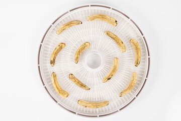 dried mini bananas on drying trays on white background
