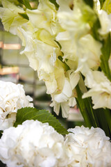 White vase with flowers in a restaurant, served table. Basket with flowers, kibana, wedding floristry.