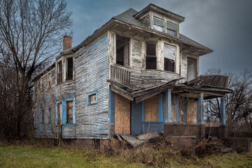 Crumbling and abandoned home with overcast sky