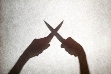 Crossed knives shadow knives. Shadows of hands with knives.