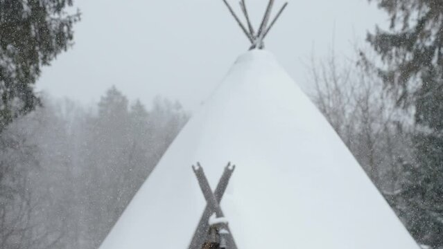 A teepee house with the thick snow on the top during a heavy snowfall winter in Estonia