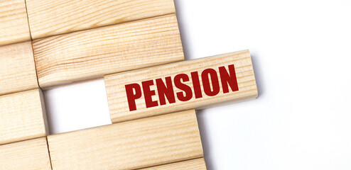 On a light background, wooden blocks with the text PENSION. Close-up top view.