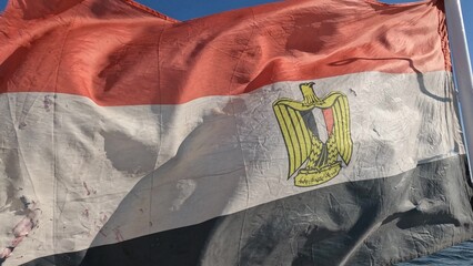 Old Flag of Egypt on background of sea and shore.