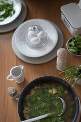 Preparation of breakfast, freshly brewed eggs, spinach, salt, sauce. Bio food, healthy raw materials. You are what you eat. All laid and laid on a wooden table.