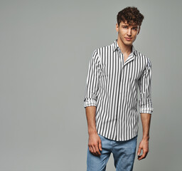Handsome man looking at camera wear striped shirt isolated on gray background