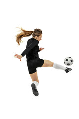 Leg kick. One sportive girl, female soccer player training with football ball isolated on white studio background. Sport, action, motion, fitness