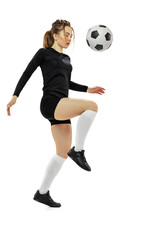 Fototapeta premium Workout. One sportive girl, female soccer player practicing with football ball isolated on white studio background. Sport, action, motion, fitness