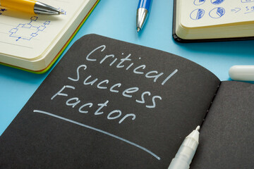 Critical success factor memo in the notepad and pen.