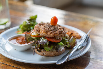 Vegetarian burger with falafel and vegetables salad, tomato, champignon and tofu cheese on plate with sweet potato
