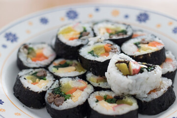 Sushi meal lined up on a round plate.