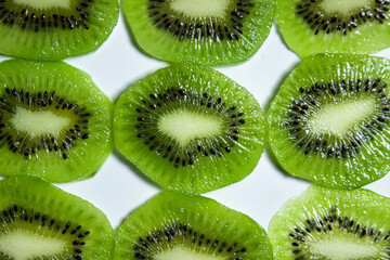 Kiwi slices in water on a white background. Peeled and sliced kiwi.