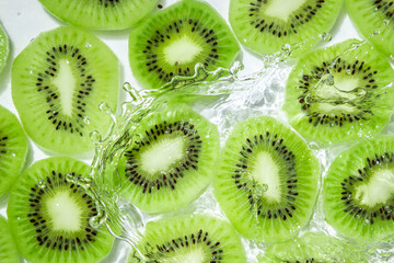 Kiwi slices in water on a white background. Peeled and sliced kiwi.