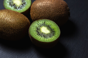 Kiwi on a black background. Kiwi cut in half. Fresh and ripe fruit